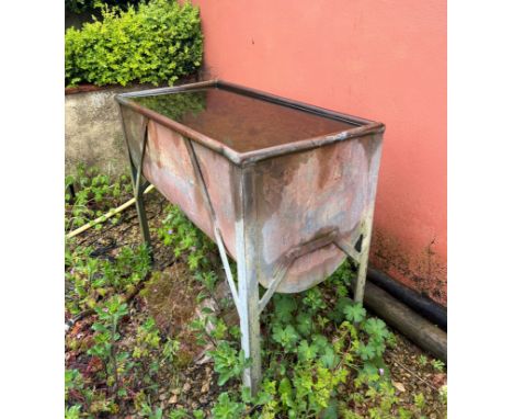 A galvanised metal water trough - with cylinder base, on four legs, 93 x 49cm, 83cm high.