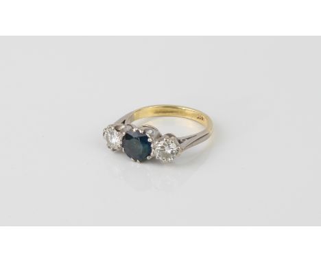 An 18ct white and yellow gold, sapphire and diamond three stone ring - the central 7mm round cut sapphire flanked by two bril