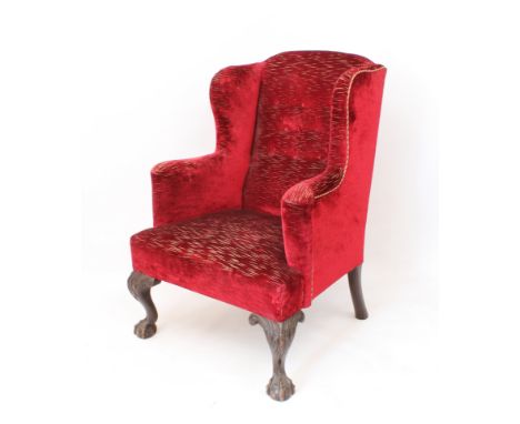 A George II style carved mahogany wingback armchair - first half 20th century, upholstered in dark-red cut velvet, raised on 
