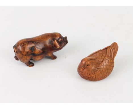 A carved fruitwood Okimono of a pig, plus a carved and signed netsuke of a Mandarin duck.