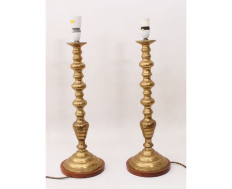 A pair of tall brass candlestick lamps in&nbsp;19th century style&nbsp;- with knopped stems and stepped, circular feet with w