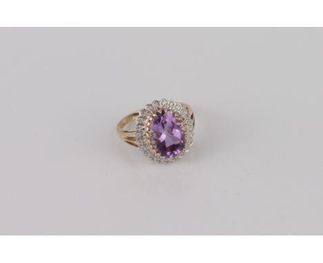 A Danbury Mint 9ct gold, amethyst and diamond cluster ring - 'The Grandeur Ring', with an oval cut amethyst within a border o