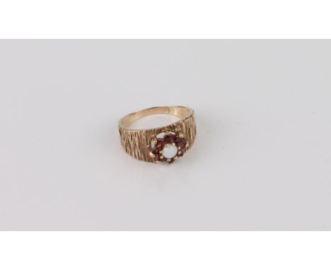 A vintage 9ct gold, white opal and garnet cluster ring - stamped '9CT', with bark effect shoulders, size O.