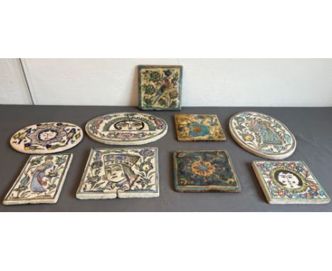 A collection of nine Persian glazed tiles - some antique, including three oval tiles, one 30 cm tile moulded and decorated wi