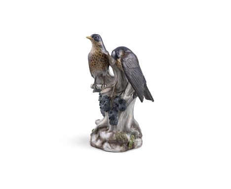 A 19TH CENTURY MEISSEN PAINTED PORCELAIN MODEL OF TWO THRUSHES,on a tree trunk with fruiting black berries, on rocky base, wi