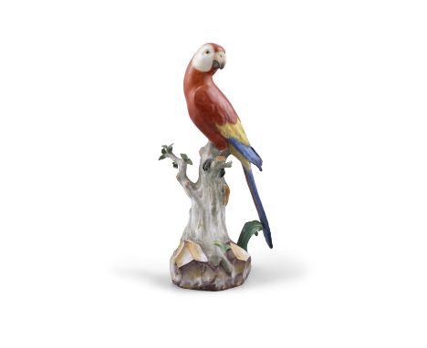 A 19TH CENTURY MEISSEN PAINTED PORCELAIN MODEL OF A RED PARROT standing on a tree stump with leafy branches, incised model nu