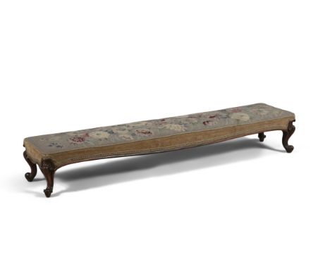 A VICTORIAN ROSEWOOD FRAMED LONG RECTANGULAR FOOT STOOL, the padded top covered in tapestry and trimmed with velvet, raised o