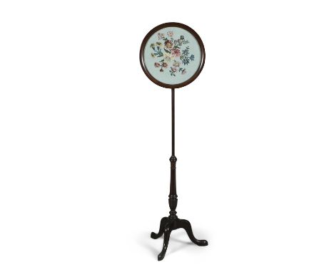 A VICTORIAN MAHOGANY FRAMED POLE SCREEN, the circular panel with needlework foliate decoration, raised on a slender tapering 