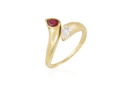 A RUBY AND DIAMOND CROSS OVER RING, composed of a pear-shaped ruby and a pear-shaped diamonds, on a plain hoop, mounted in 18