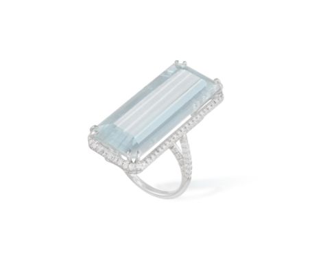 AN AQUAMARINE AND DIAMOND COCKTAIL RING, composed of a large elongated rectangular-cut aquamarine weighing 26.77cts, within a
