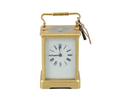 AN EDWARDIAN GILT BRASS CASED CARRIAGE CLOCK, with striking movement and white enamel dial. 17cm high over raised handle; cas
