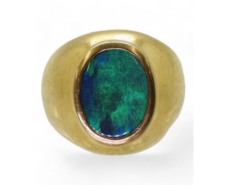 A GENTS OPAL SET RING the wide dome shaped ring is made of 18ct yellow gold , set with a 14mm x 10mm x 4mm opal doublet, fing