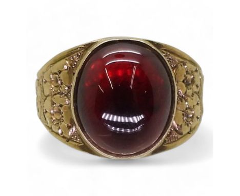 A GARNET RING the mount in 9ct gold with engraved flower details to the shoulders is hallmarked Birmingham 1970, finger size 