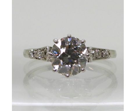 A VINTAGE DIAMOND SOLITAIRE RING the white metal mount is set with an old cut diamond of estimated approx 1.80cts, with three