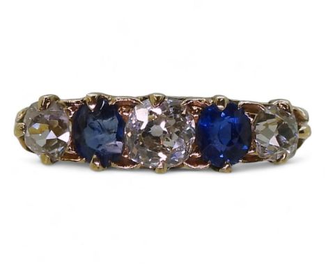 A FIVE STONE RING set with two oval cut sapphires and three old cut diamonds with an estimated approx combined total of 0.80c