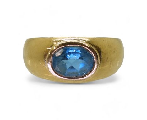 A GENTS BLUE TOPAZ RING in a bright yellow metal domed ring mount, stamped 750. Finger size W1/2, weight 9.4gms Condition Rep
