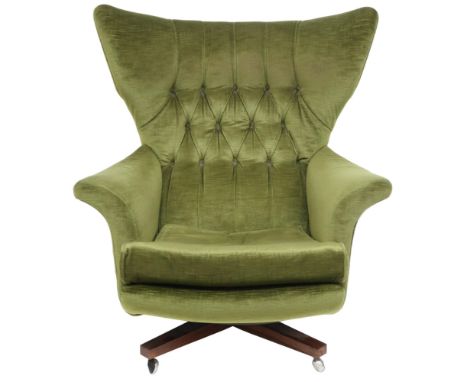 A MID 20TH CENTURY G PLAN MODEL 62 "BLOFELD" SWIVEL ARMCHAIR&nbsp; with green velour button backed upholstery on stained teak