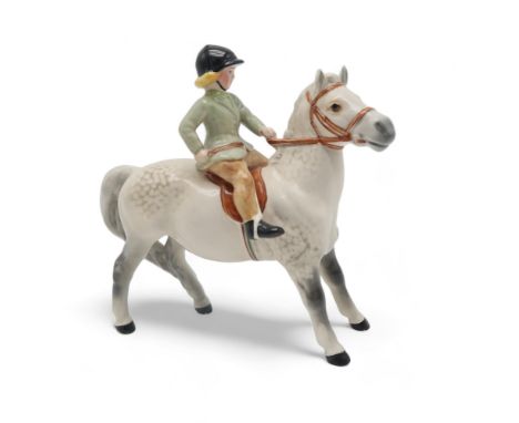 BESWICK GIRL ON LIGHT DAPPLE GREY PONY wearing a green jacket, model 1499 Condition Report:There is a tiny nibble to the tip 