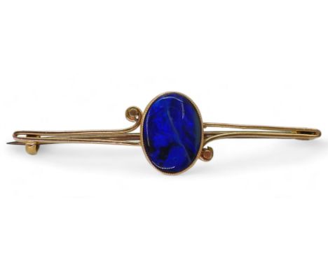 A BLACK OPAL BROOCH in a 15ct mount. The opal is approx 12mm x 9mm x3.5mm. Cobalt &amp; teal colour flashes. Length of brooch