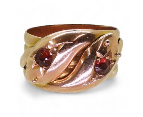 A ROSE GOLD DOUBLE SNAKE RING the 9ct gold serpents heads are set with garnets, bears a London hallmark for 1919, finger size