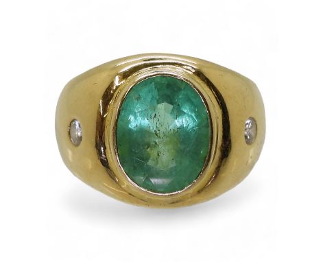 A GENTS EMERALD & DIAMOND RING mounted in bright yellow metal, set with a 12mm x 10mm x 7.5mm oval cut glass bonded emerald a