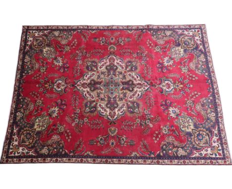 A RICH RED GROUND PERSIAN CARPET&nbsp; with multicoloured central medallion and spandrels on ground decorated with floral/fol