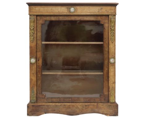 A VICTORIAN WALNUT AND SATINWOOD PIER CABINET&nbsp; with brass ormolu mounts and ceramic inset plaques surrounding single gla