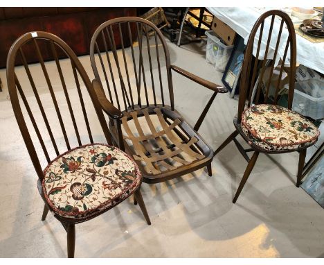 An Ercol low seat stick back armchair; two Ercol stick back high hoop dining chairs 