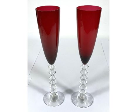 BACCARAT: a set of of two Vega Flutissimo crystal champagne flutes, etched signature to bases, red and clear stems (one chipp
