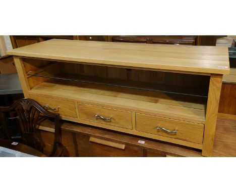 A modern light oak low unit with shelf below and three drawers 