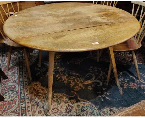 A 1960's Ercol, light elm, circular drop leaf dining table. 