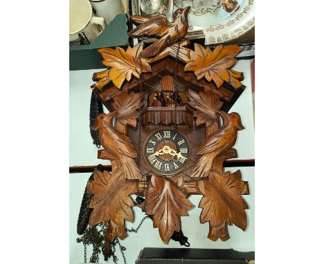 An early to mid 20th century Bavarian cuckoo clock with dancing and spinning figures and carved case 
