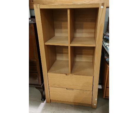 A modern lightwood open shelf quartered bookcase with drawer bellow 