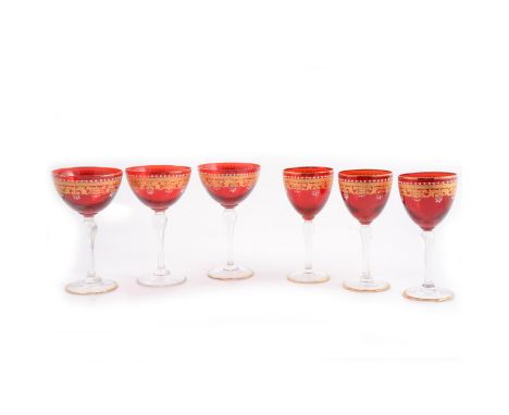 A suite of Murano Salviati Venetian stemware, with ruby glass bowls decorated with white enamel and gilt borders, clear glass