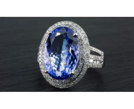 A 14ct white gold, Tanzanite and diamond cluster ring, the approx. 7.5 carat oval cut Tanzanite within a stepped two-row bord