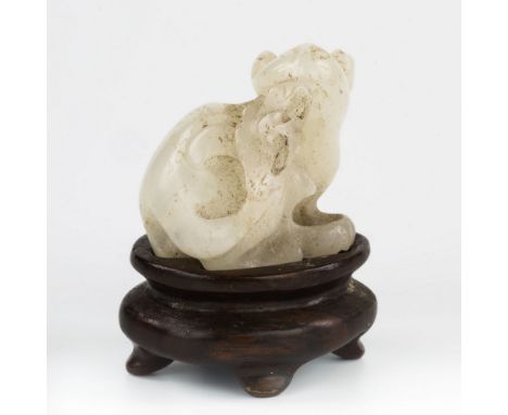 A Chinese white jade miniature carving, depicting a rodent biting a bat, probably 19th century, 2.3cm. high, on fitted hardwo