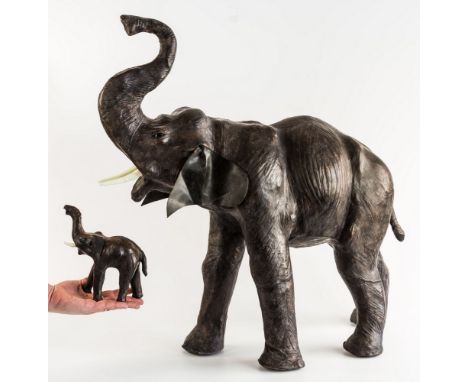 A large leather elephant form footstool, third quarter 20th century, realistically modelled with undulating body and striated