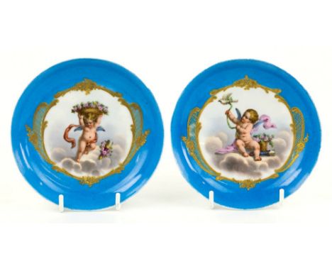 A pair of Sevres porcelain blue celeste ground saucers, 19th century, finely decorated with winged putti in clouds, one holdi