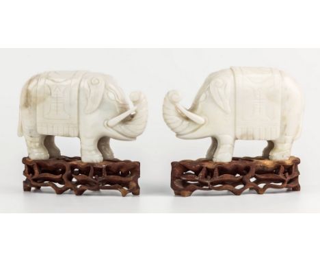 A pair of Chinese carved mutton fat jade elephants, probably 19th century, archaistic in execution, modelled standing four sq