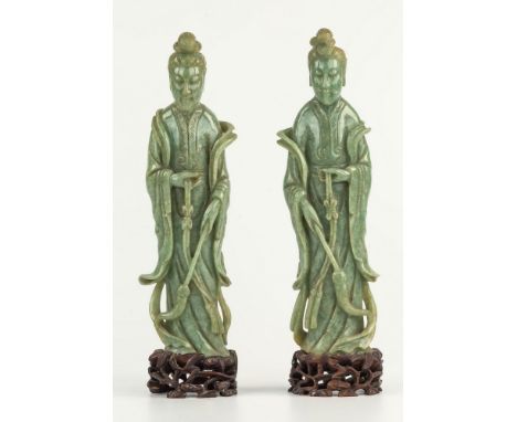 A pair of Chinese carved pale spinach jade figures of Guanyin, probably 19th century, standing in flowing robes and holding h
