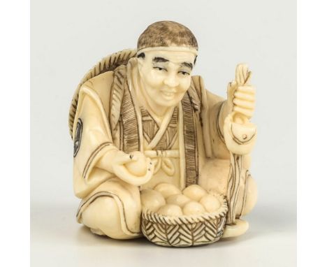 A finely carved Japanese ivory netsuke, Meiji period (1868-1912), depicting a street vendor selling wares from a basket clasp