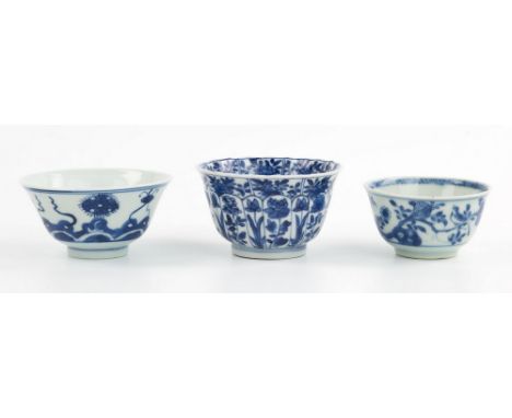 Three Kangxi period Chinese blue and white porcelain tea bowls, one of lotus form, the moulded petals each with single flower