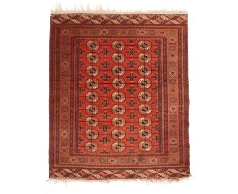 A Tekke Bokhara rug, first half 20th century, the madder field with three rows of nine typical octagonal medallions, within m