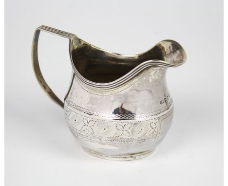 A George III silver cream jug, John Merry, London 1810, helmet shaped with reeded handle and rim, decorated with punchwork an