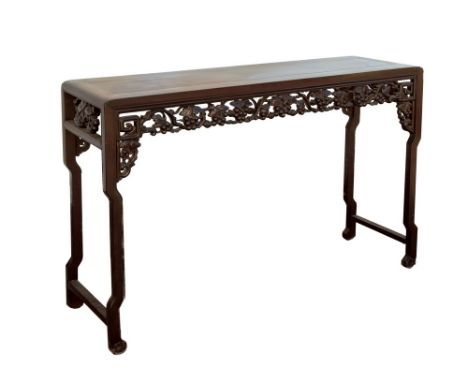 A Chinese antique carved hardwood altar table, late 19th / early 20th century, the cleated top over a pierced and carved frui