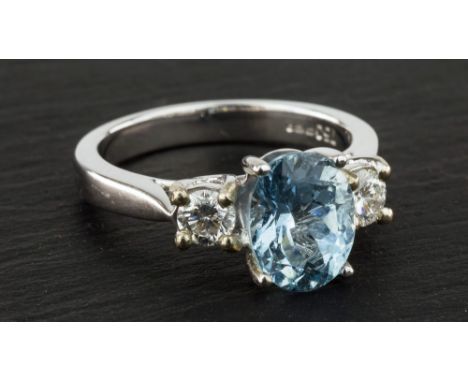 An 18ct white gold, aquamarine and diamond three stone ring, the 1.95ct oval cut aquamarine with a single brilliant cut diamo