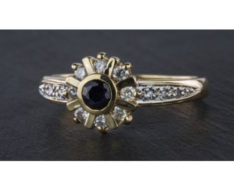 A 9ct yellow gold and black & white diamond cluster ring, the floral set round cut black diamond within a border of eight bri