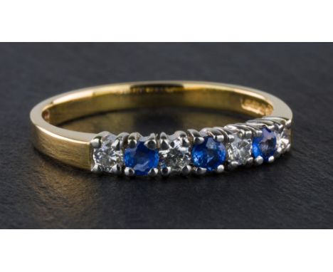 A 9ct yellow gold, sapphire & diamond half eternity ring, set with three pale blue round cut sapphires and four brilliant cut