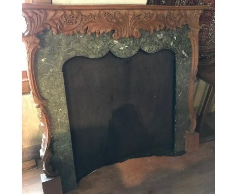 A carved wood fire surround, with a simulated marble inset, 134 cm wide x 118 cm high 