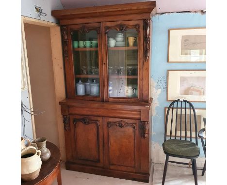 A late Victorian walnut bookcase, having a pair of glazed doors, above a drawer, with a pair of panel doors below, 123 cm wid